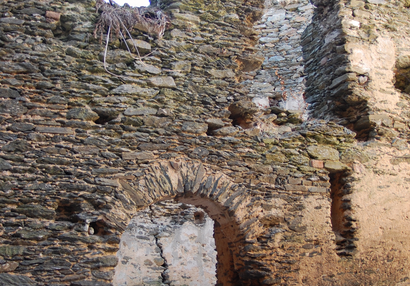 Front of the building in the western part of the courtyard with entrances to both floors and slotted loophole.