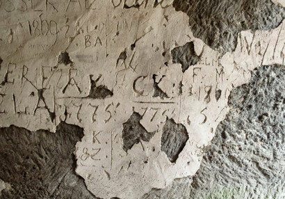 Nejstarší návštěvnická datace z roku 1775 na omítce kryjící osekanou skalní stěnu.