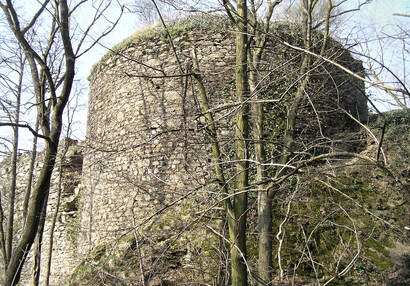 Blick von außen auf die mächtige Bastei, die die Form einer Dreiviertelwalze hat.